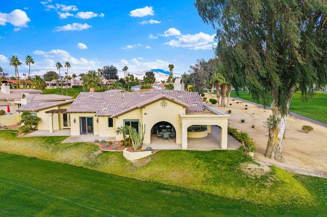 rear view of house with a yard and a patio area