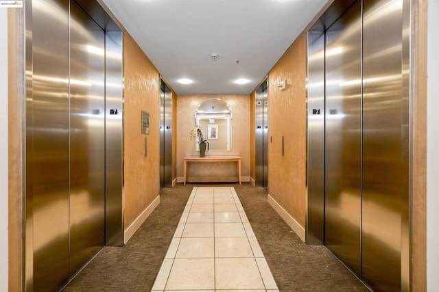 corridor with tile patterned floors and elevator