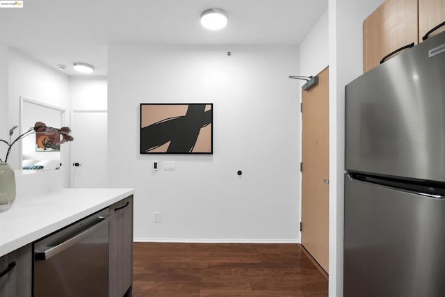 kitchen with appliances with stainless steel finishes and dark hardwood / wood-style floors