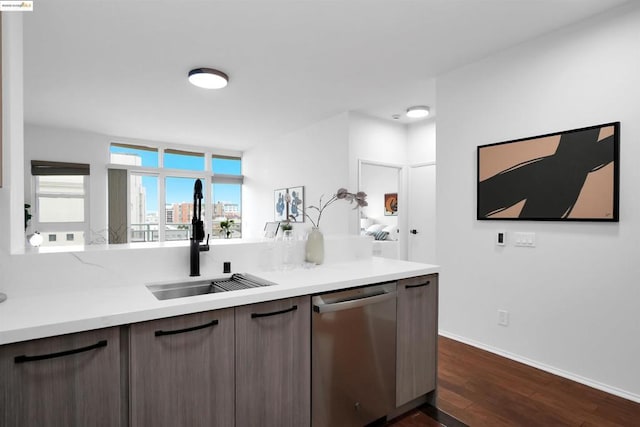 kitchen featuring dark brown cabinetry, dark hardwood / wood-style floors, dishwasher, and sink