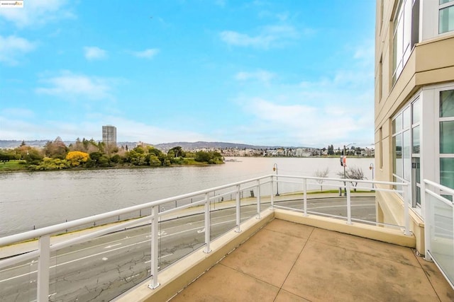 view of patio / terrace with a water view and a balcony