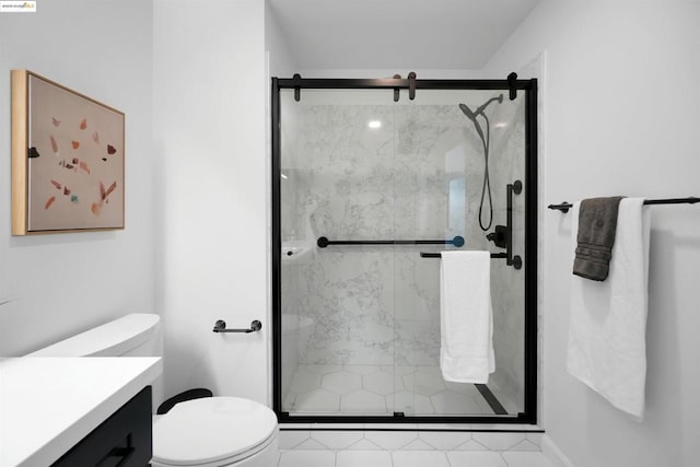 bathroom featuring a shower with door, vanity, and toilet