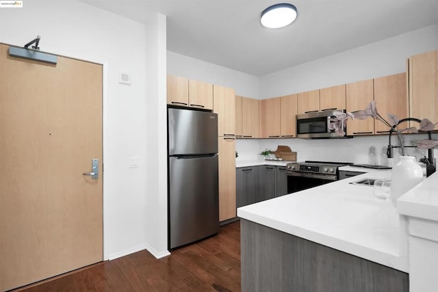 kitchen featuring stainless steel appliances, dark hardwood / wood-style floors, and light brown cabinetry