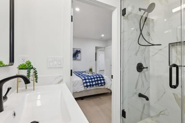 bathroom with a shower with door, hardwood / wood-style flooring, and sink