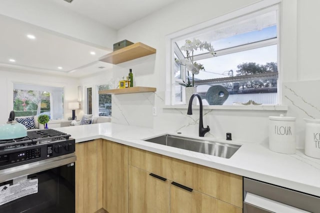 kitchen with range with gas stovetop, sink, decorative backsplash, stainless steel dishwasher, and light stone countertops