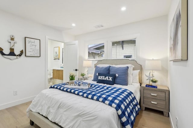 bedroom featuring ensuite bathroom and light hardwood / wood-style floors