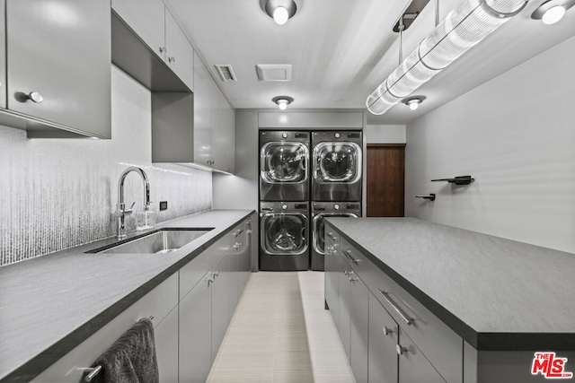 laundry room featuring cabinets, separate washer and dryer, sink, and stacked washer and dryer