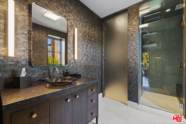 bathroom with vanity, a shower with door, and decorative backsplash