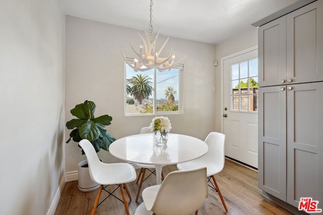 dining space featuring an inviting chandelier and light hardwood / wood-style floors