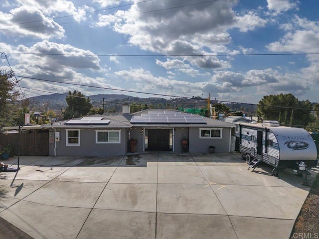 view of front of property featuring a mountain view and solar panels