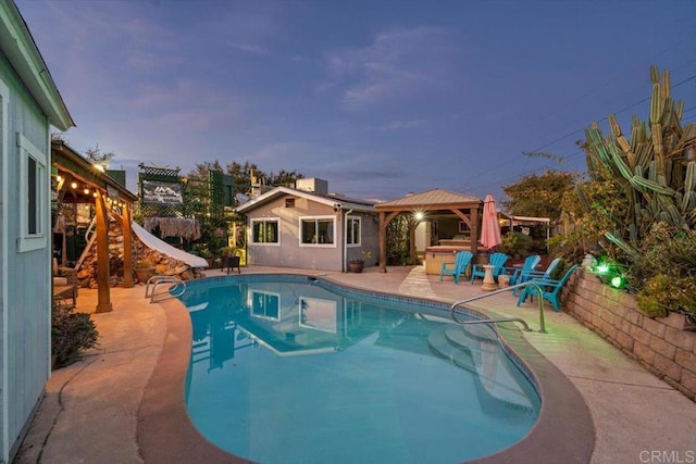 pool at dusk featuring a gazebo, a water slide, and a patio