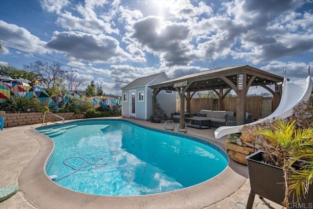 view of swimming pool featuring an outbuilding, a water slide, an outdoor hangout area, and a patio