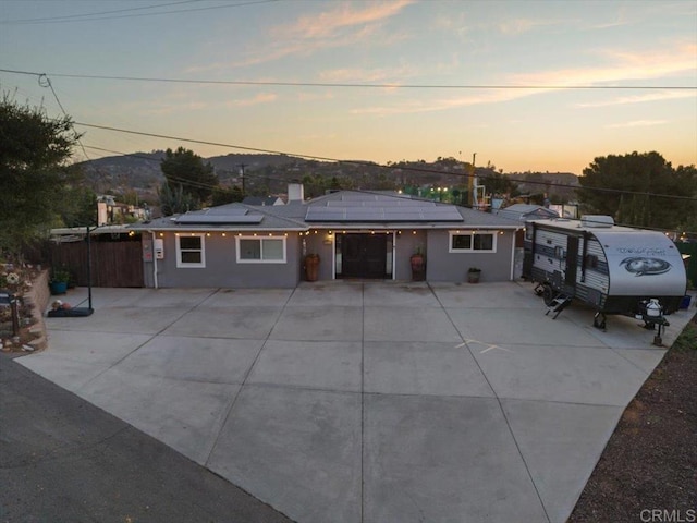 view of front of home with a mountain view and solar panels