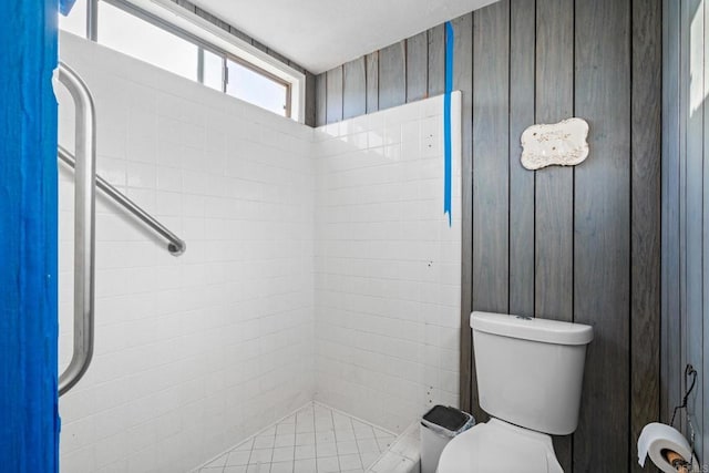 bathroom featuring tiled shower and toilet