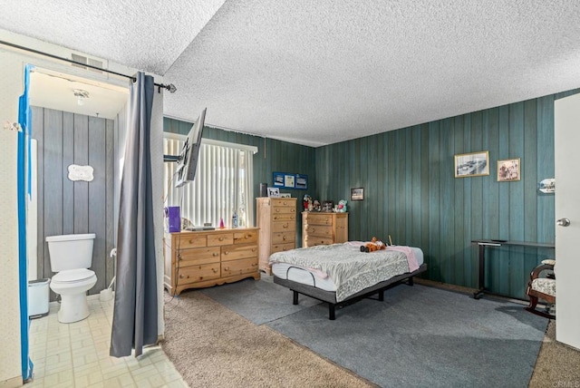 bedroom featuring ensuite bath and a textured ceiling