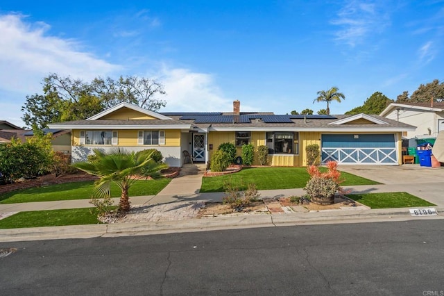 ranch-style house with a garage, a front lawn, and solar panels