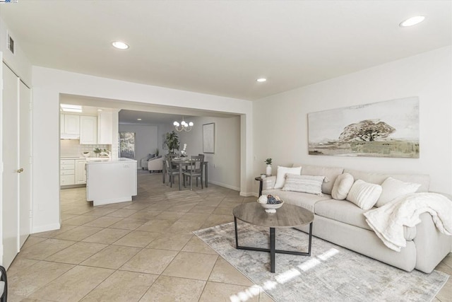 tiled living room with a notable chandelier