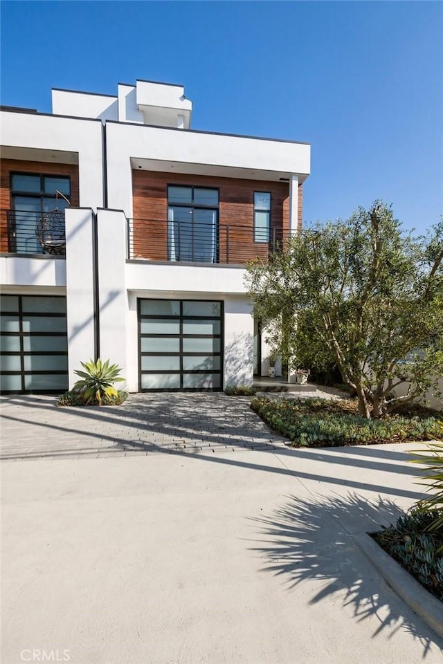 contemporary home featuring a balcony and a garage