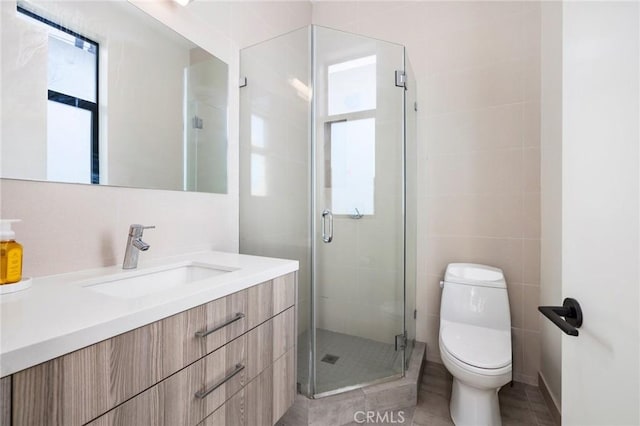 bathroom featuring walk in shower, tile patterned floors, toilet, tile walls, and vanity