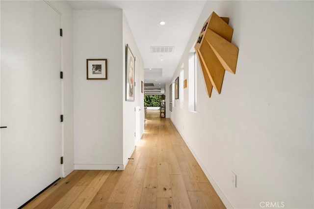 hallway with light hardwood / wood-style floors