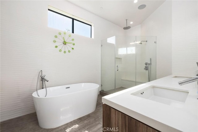 bathroom with vanity, shower with separate bathtub, and tile walls