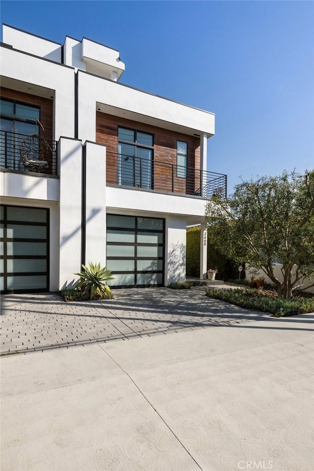 contemporary home featuring a garage and a balcony