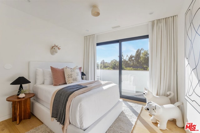 bedroom featuring access to exterior and light hardwood / wood-style floors