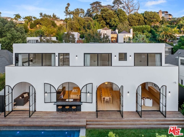 rear view of house featuring a pool side deck