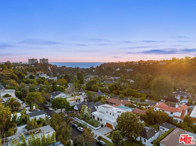 aerial view at dusk featuring a water view