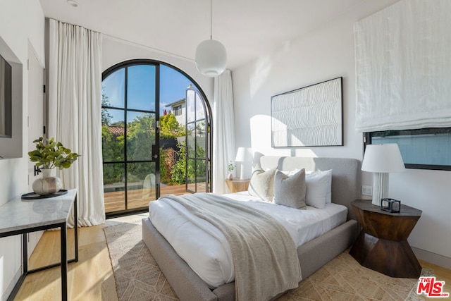 bedroom featuring access to exterior and light wood-type flooring