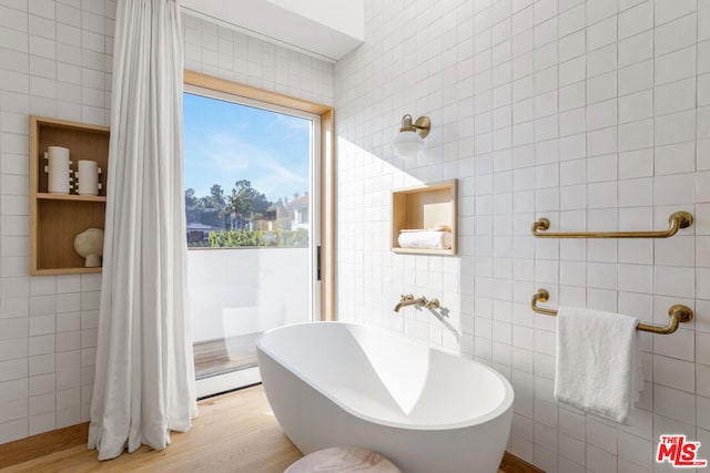 bathroom with tile walls and a tub to relax in