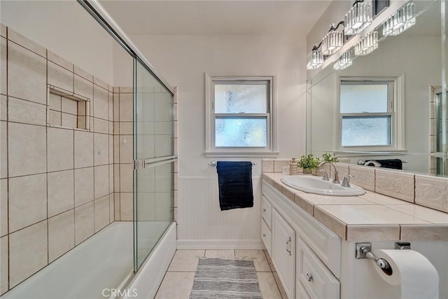 bathroom with tile patterned flooring, enclosed tub / shower combo, and vanity