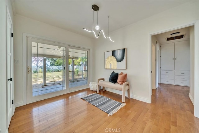 living area featuring crown molding and light wood-type flooring