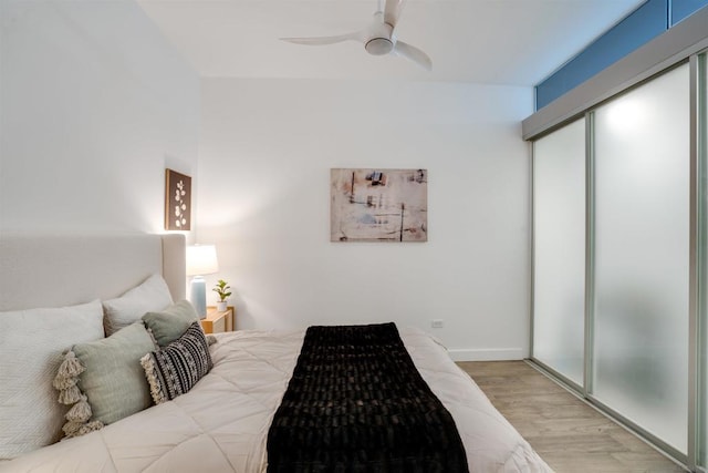 bedroom featuring ceiling fan, light hardwood / wood-style floors, and a closet