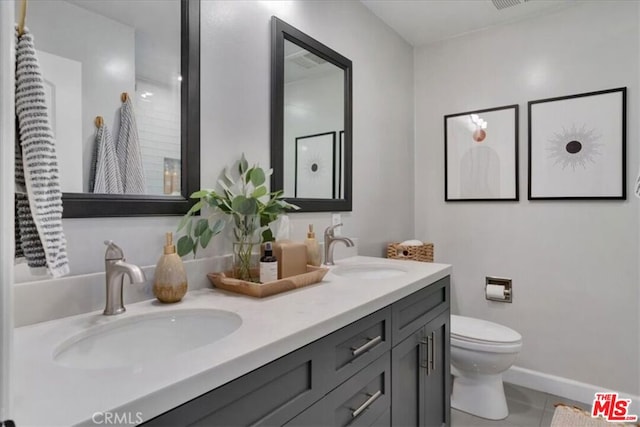 bathroom featuring vanity, tile patterned floors, and toilet