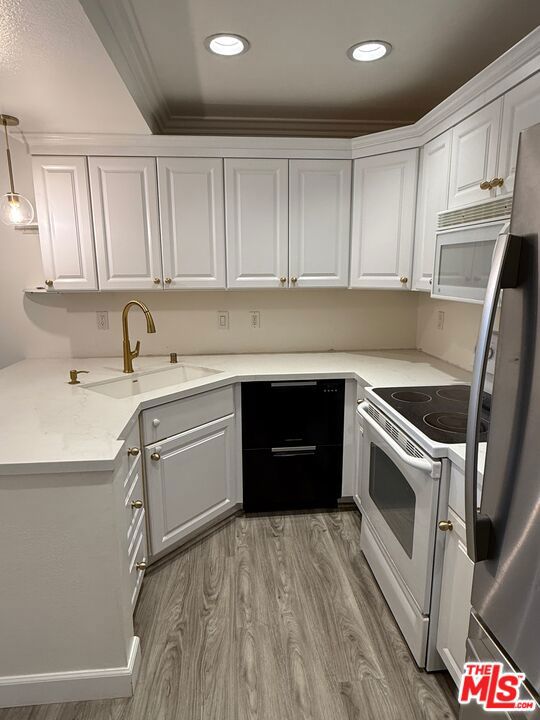 kitchen with sink, white appliances, and white cabinets