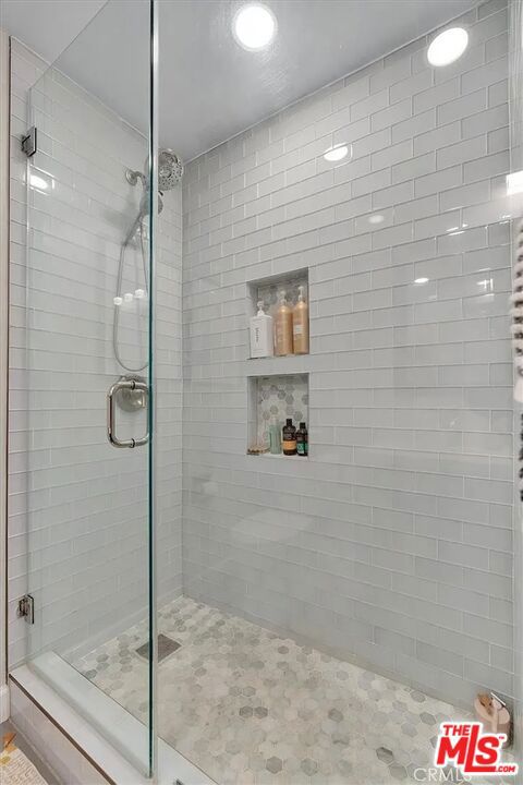 bathroom featuring a shower with door