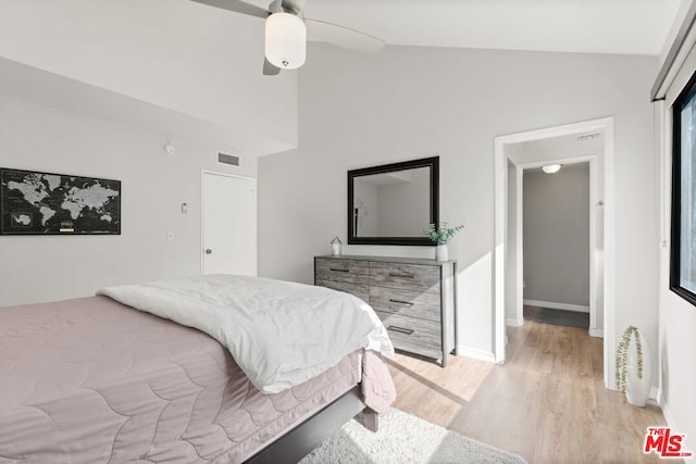 bedroom with ceiling fan, lofted ceiling, and light wood-type flooring