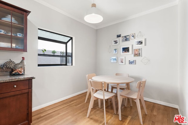 dining area featuring ornamental molding and light hardwood / wood-style floors