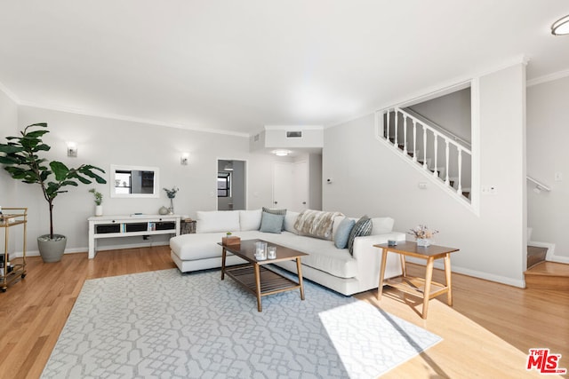 living room with ornamental molding and hardwood / wood-style floors