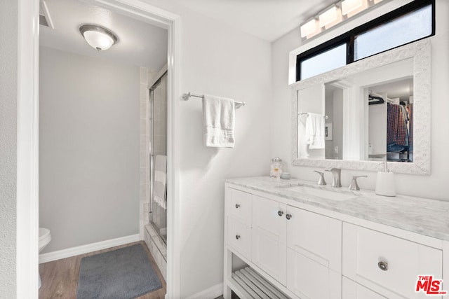 bathroom with walk in shower, vanity, toilet, and hardwood / wood-style flooring