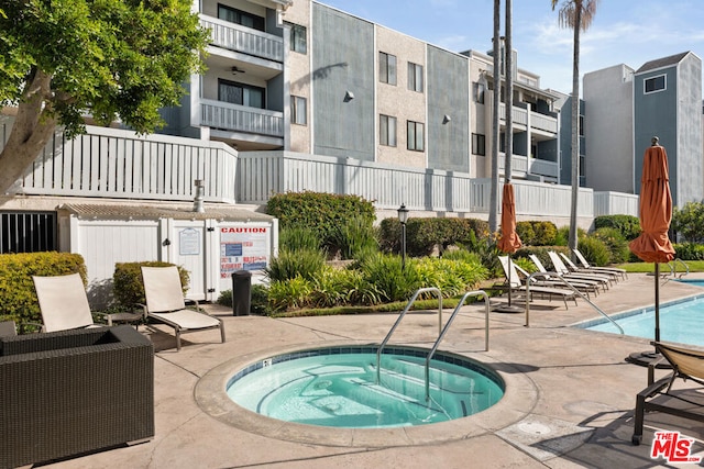 view of pool featuring a hot tub and a patio area