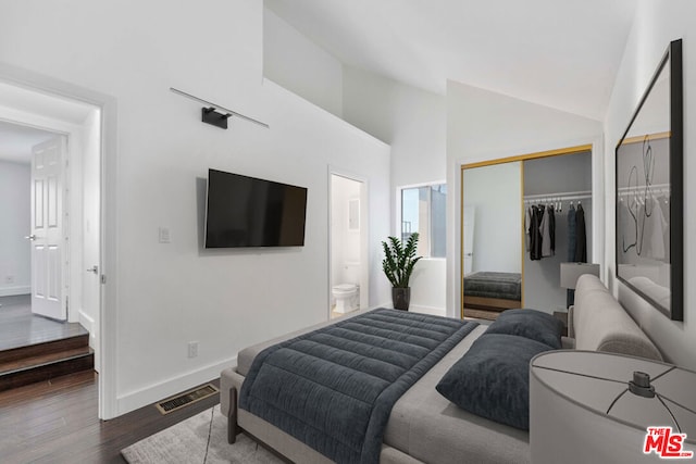 bedroom with lofted ceiling, hardwood / wood-style floors, ensuite bath, and a closet