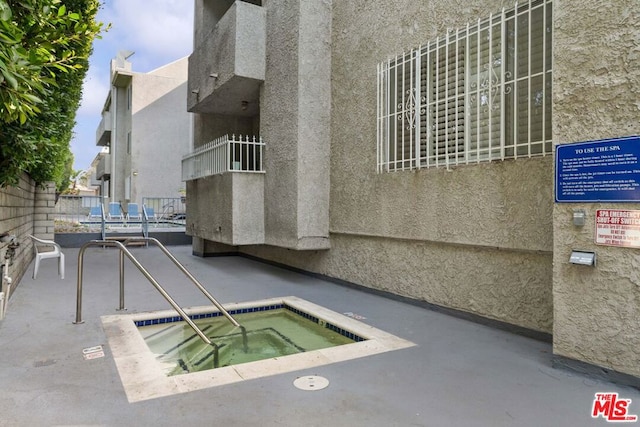 view of pool with a hot tub