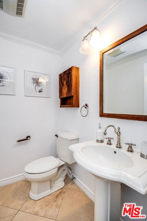 bathroom with crown molding, toilet, and tile patterned flooring