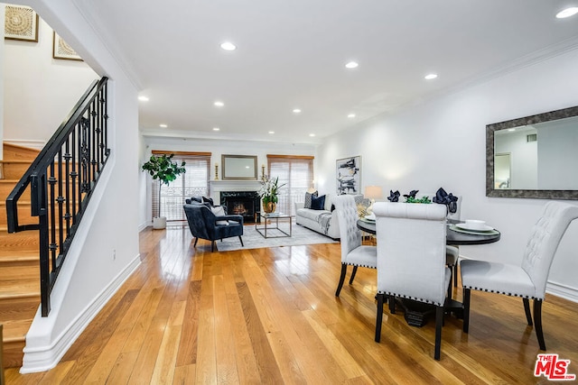 dining space with crown molding and light wood-type flooring