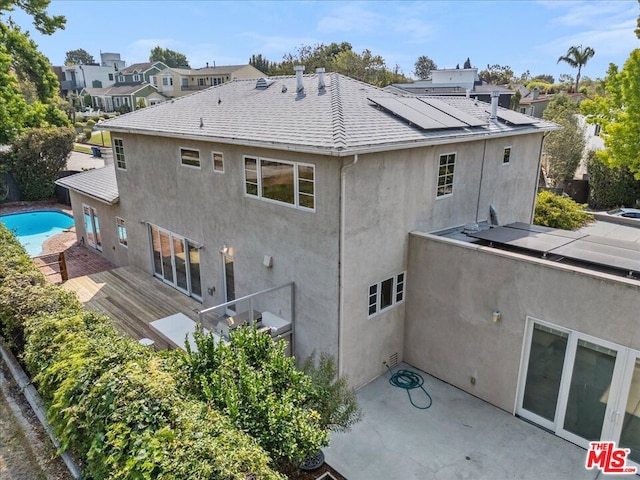 rear view of property with solar panels