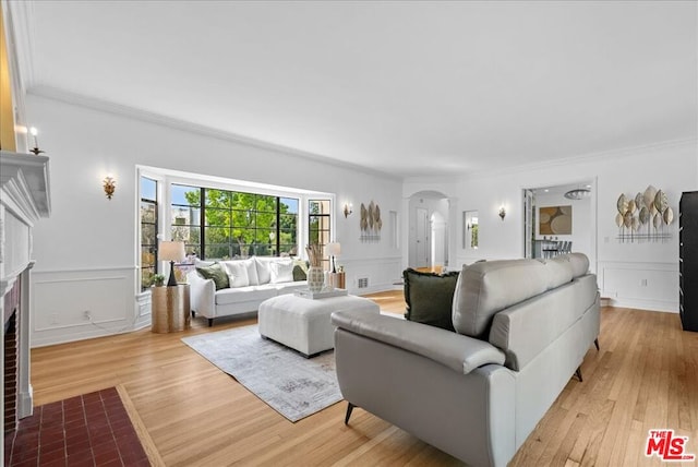 living room with light hardwood / wood-style flooring and ornamental molding