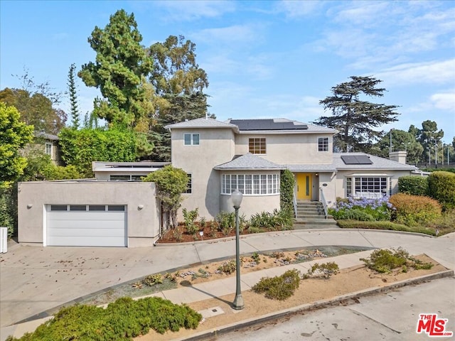 view of front of property with a garage and solar panels