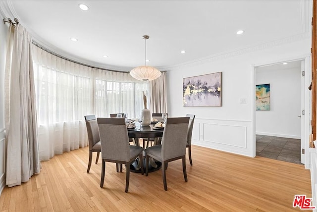 dining space featuring crown molding and light hardwood / wood-style flooring